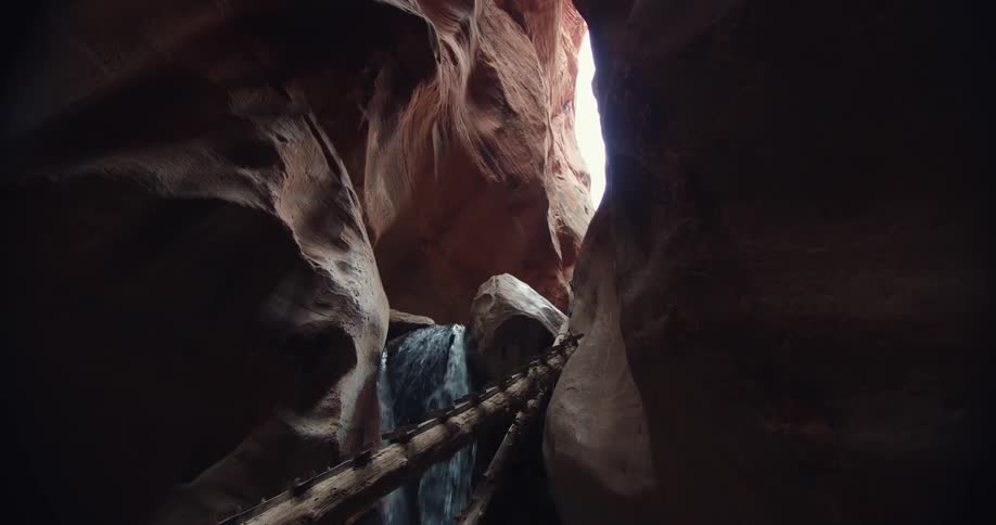 Waterfall flowing down a gorge inside a canyon at daytime