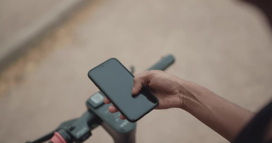 A female is holding a cell phone and moving her thumb across the screen