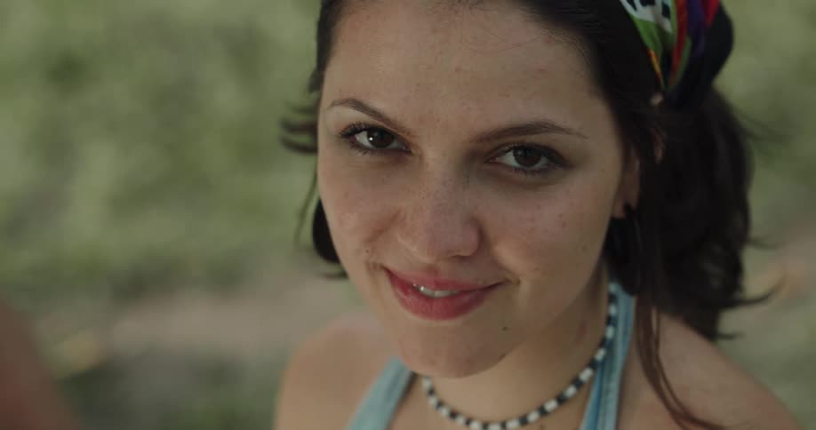 A woman is standing outdoors and smiling