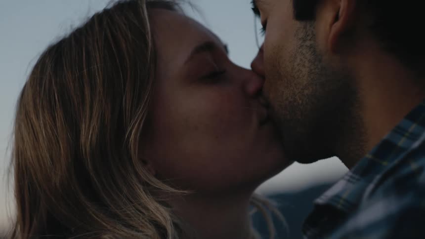 A couple look into each others eyes and embrace into a kiss