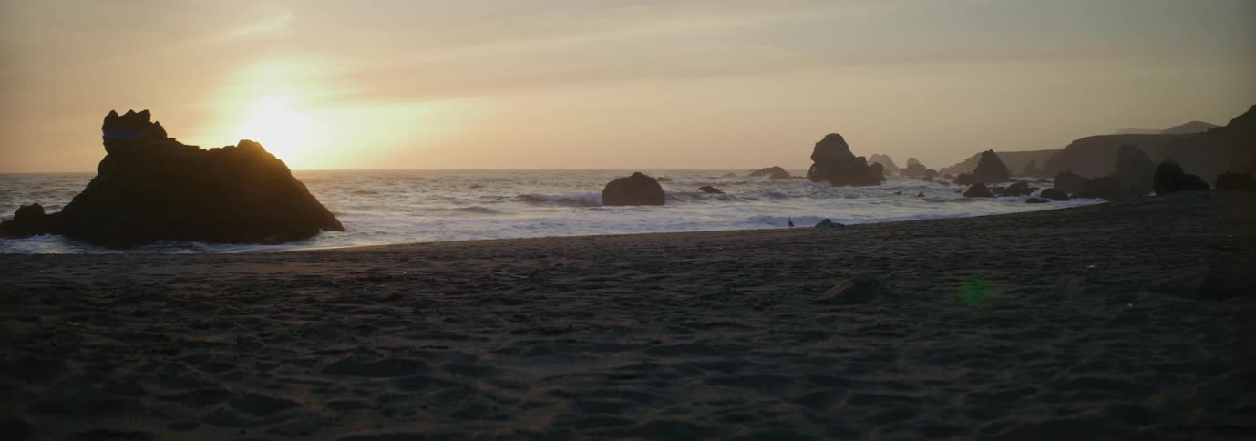 Waves wash into a sandy beach in the evening