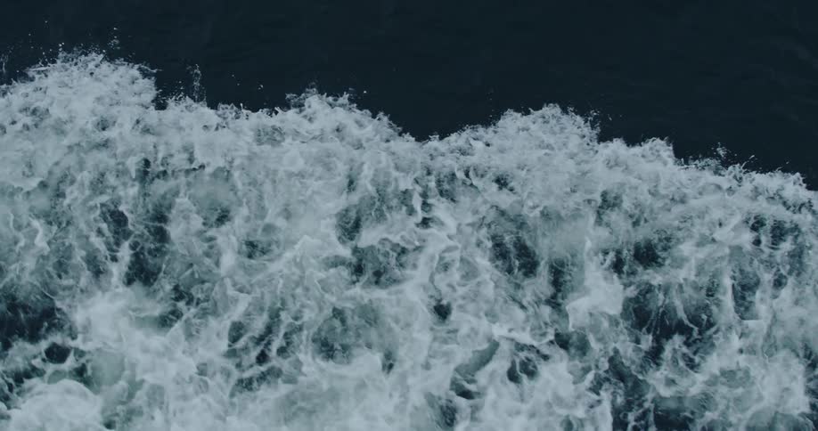 Aerial view of ocean waves crashing in slow motion
