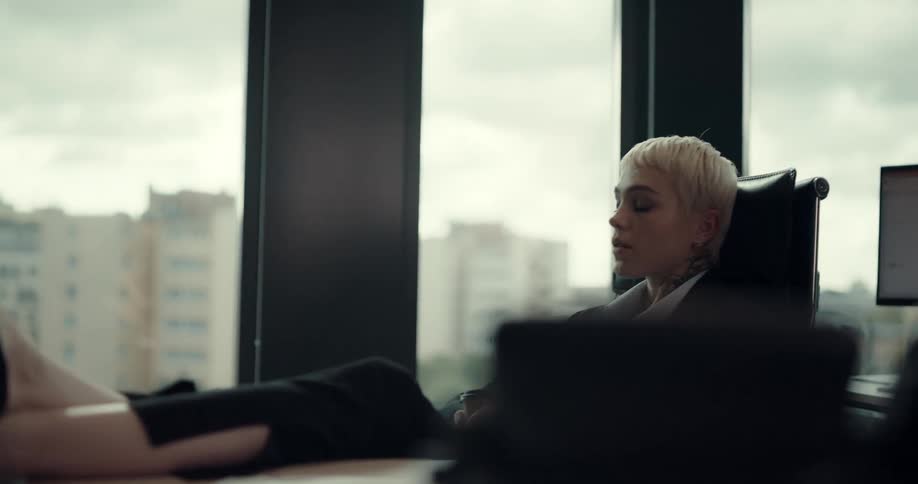 A woman is sitting in her office with a cup of coffee