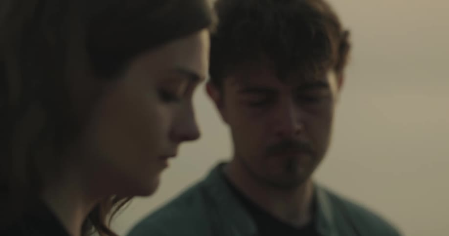 Woman and man are standing outdoors together at dusk