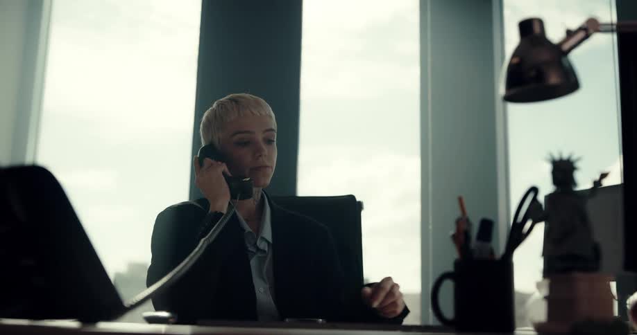 A woman talks on the phone at her desk