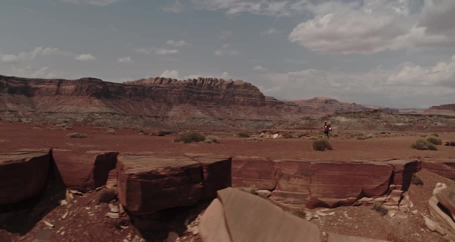 A man is hiking through the valley and cliffs