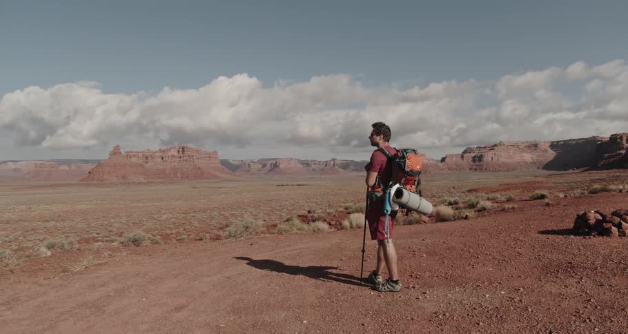 A man is hiking through valleys by himself