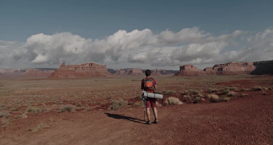 A man is hiking outdoors through a valley in spring