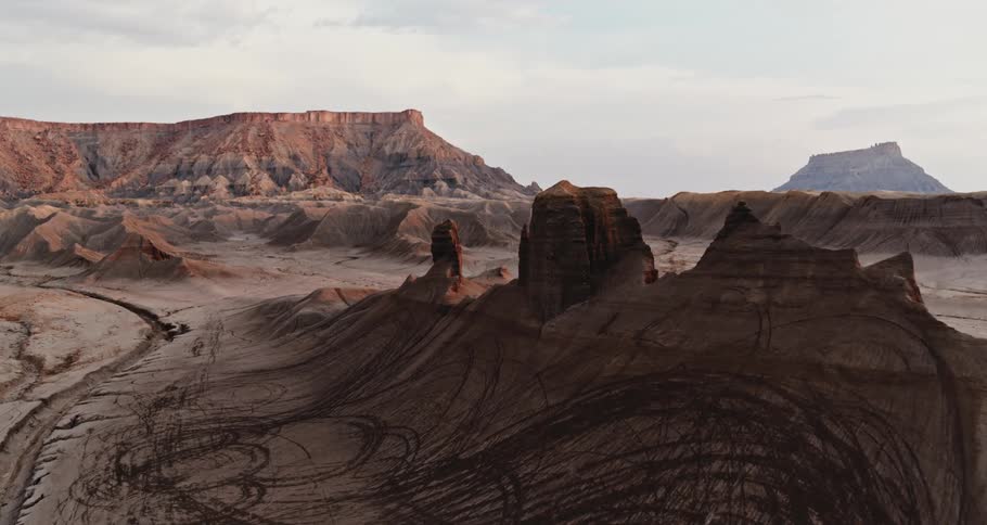 Aerial view of rock formations in the desert badlands and mesa in the distance