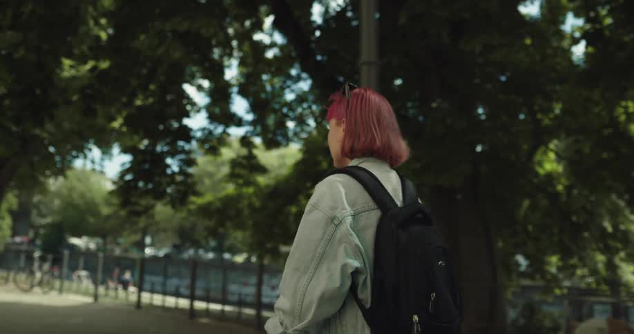 A girl looks around while riding a scooter