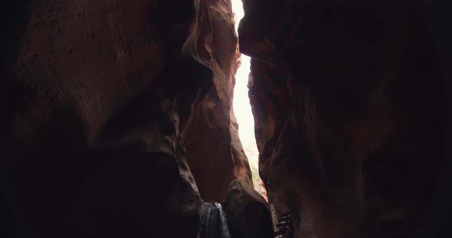 A small waterfall rushes down a ridge in a cave