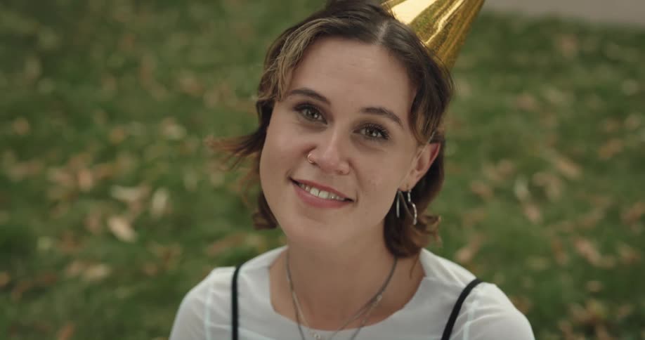 A woman in a party hat smiles