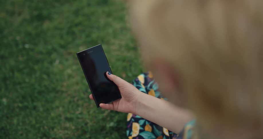 A girl is outside using her cell phone
