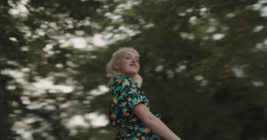 A woman is dancing outdoors during the spring time