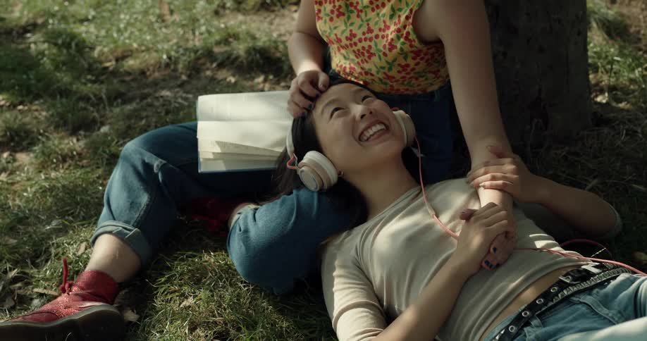 A woman lays with her head in a friends lap