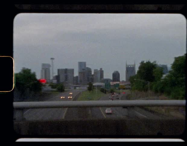 Traffic flows to and from city along controlled access freeway passing under bridge