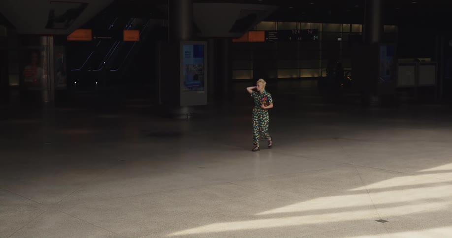 A woman is walking through a building in a city