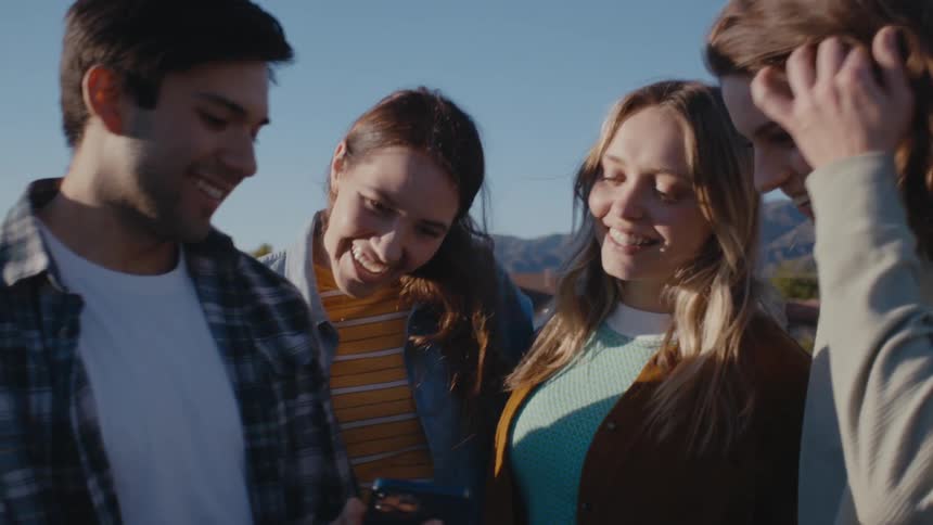 A group of women pulls a man into a group hug