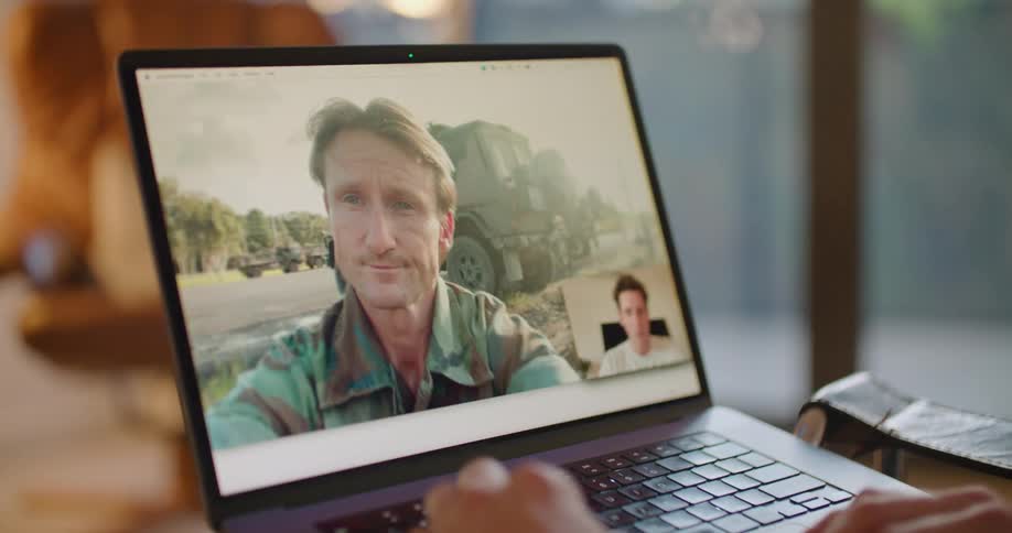 A man is having a video conversation with another man on a laptop computer
