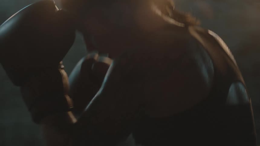 A woman throws punches at a bag as she boxes