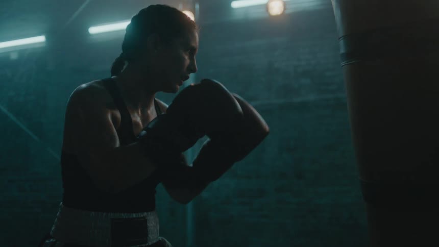 A woman is boxing indoors by herself