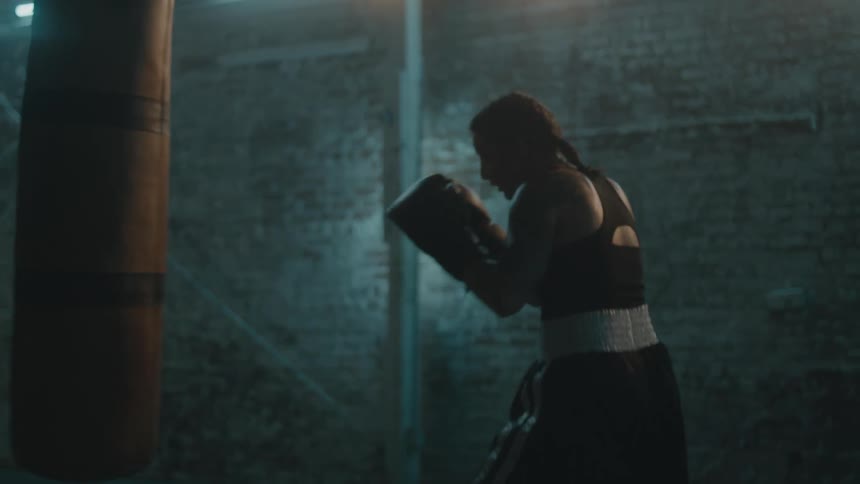 A woman is punching the heavy bag