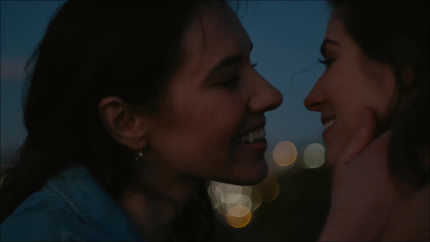A couple kiss near the city