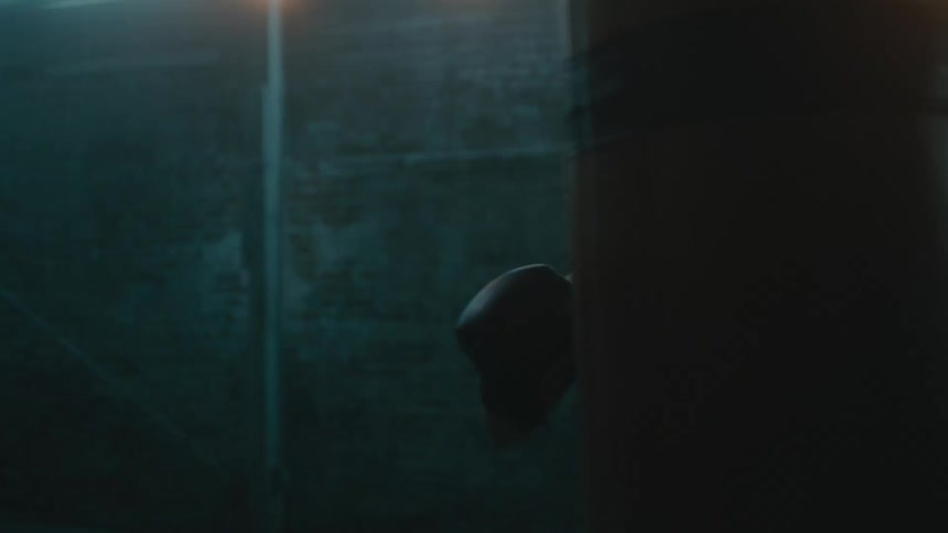 A woman is boxing by herself in a room