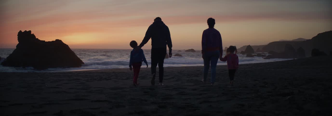 A family walk on the beach together