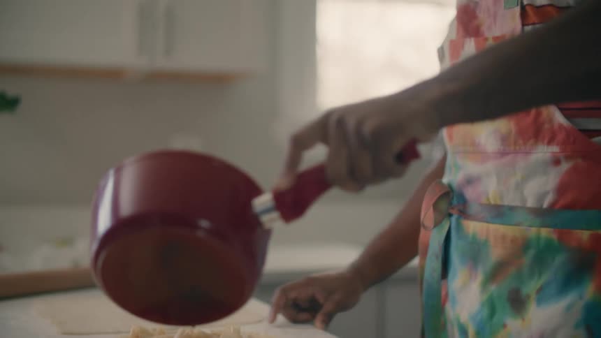 A man is cooking a meal in his kitchen during the day time