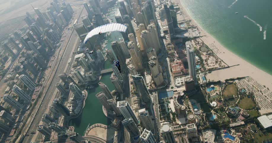 A person parachutes over a city