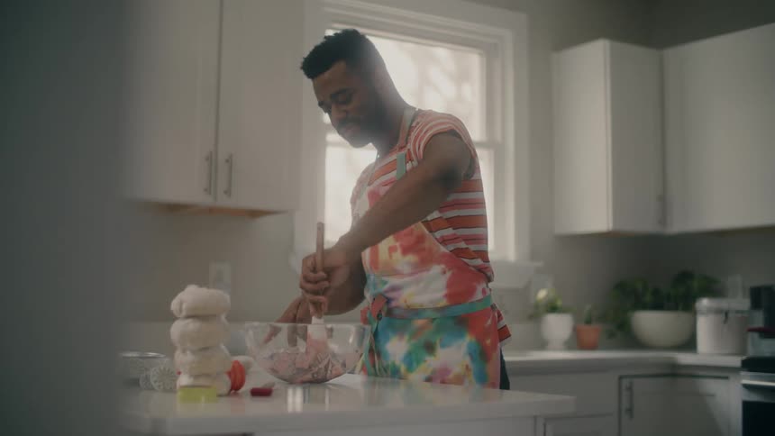 A man is mixing ingredients in his kitchen