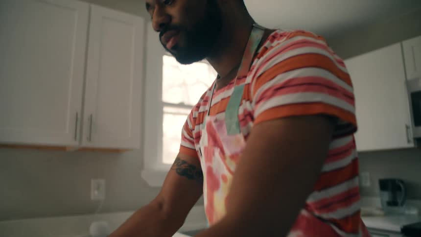 A black man prepares a pie in a kitchen