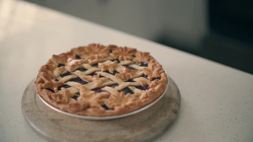A berry fruit pie cooling on a kitchen counter