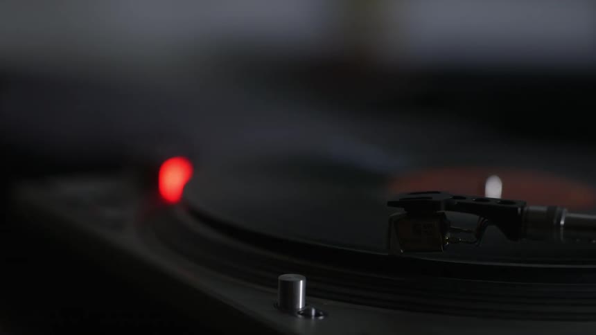 A person moves a record player needle