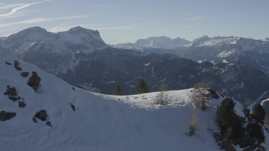 A snow capped mountain range under a clear daytime sky