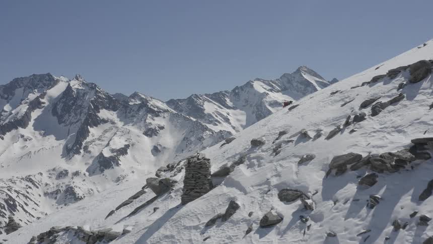Aerial view of a skier climbing the snow covered slope of a mountain at daytime
