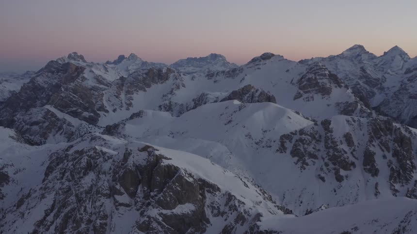 Snow covered mountain ridge with peaks high in a clear sky
