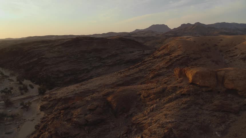 Aerial view of dramatic desert mountains at dusk