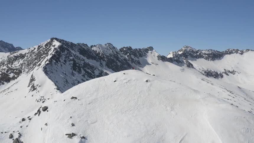 Aerial view of human standing on top of snowy mountain