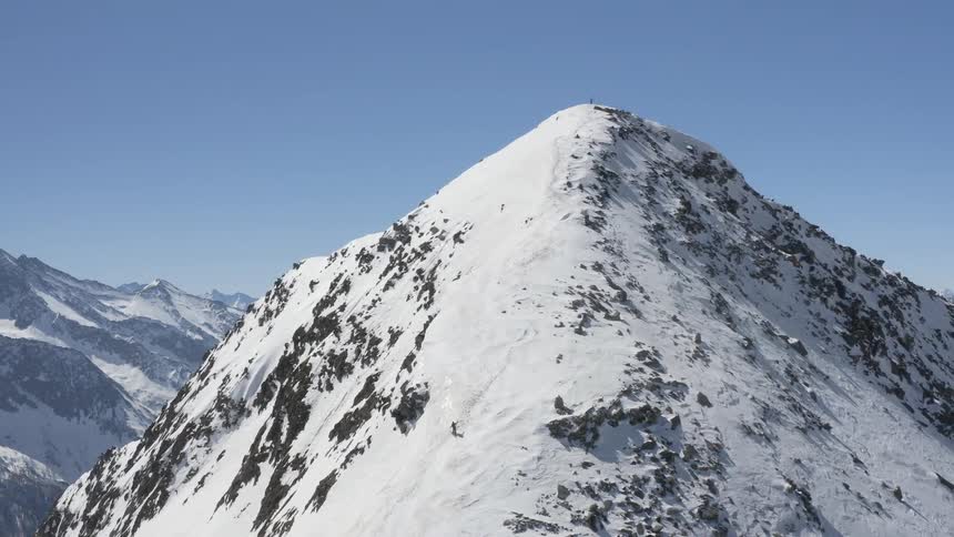 Snow covered mountains with peaks high in a clear blue sky