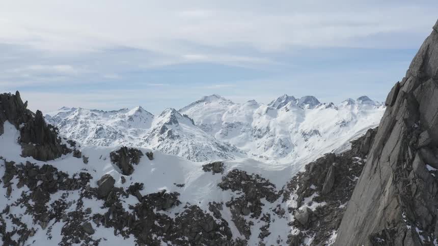 A vast mountain range covered in snow during the day