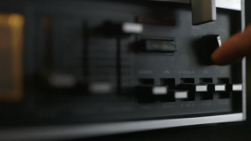 Close up of a hand moving knobs on a machine