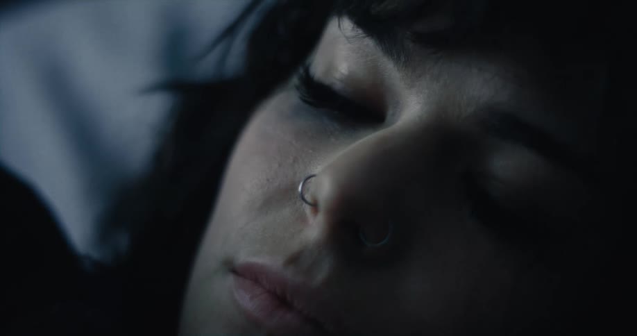A womans eyelashes flutter as she blinks while lying down