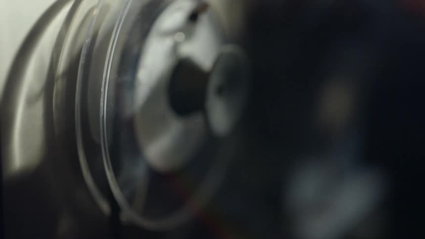 A person spools tape on a machine