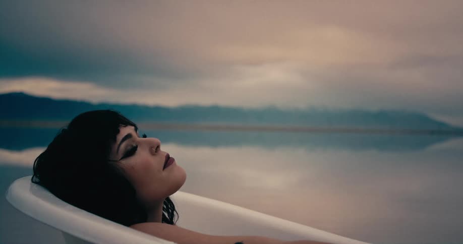 A woman laying in a bathtub outdoors