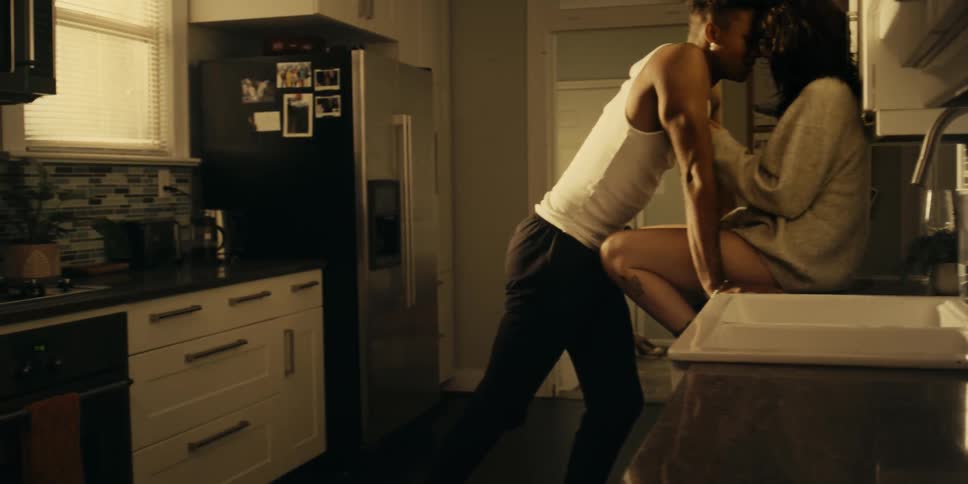 Woman sleeping in the bedroom while friends kiss and talk on the kitchen at home