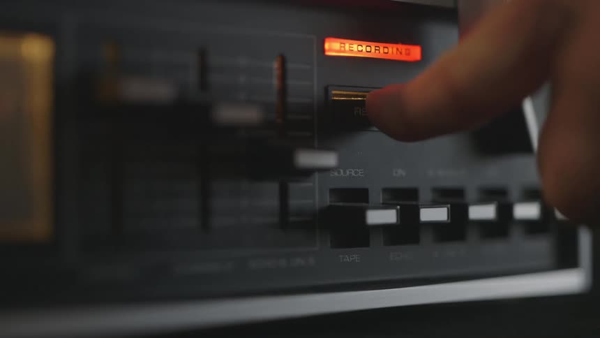 Finger pushes a recording button on a stereo