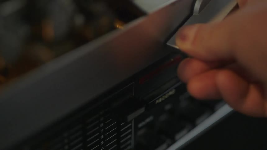 A hand pushes some knobs on a machine