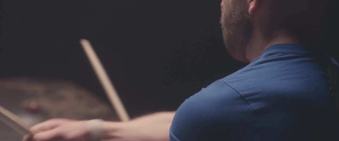 A man moves to be beat while playing the drums
